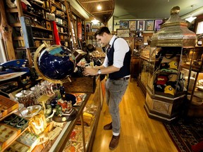 Alexander Archbold works on a recently purchased gramophone at his Curiosity Inc. collectibles store, located in Westmount.