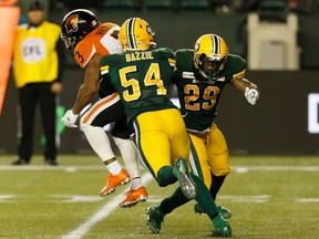 Edmonton Eskimos' Alex Bazzie (54) and Brian Walker (29) tackle BC Lions' John White IV (3) in the backfield during second half CFL action at Commonwealth Stadium in Edmonton, on Saturday, Oct. 12, 2019.