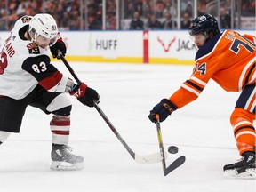 Edmonton Oilers' Ethan Bear (74) battles Arizona Coyotes' Conor Garland (83) during the first period of a NHL hockey game at Rogers Place in Edmonton, on Monday, Nov. 4, 2019.