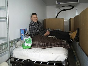 Dan Johnstone gets comfortable on his cot in the back of a truck where he will be camping out to raise as much food, money and awareness for various food banks around Alberta. He has been doing his “Moving Hunger Out” Winter Campouts every winter since 2011. (PHOTO BY LARRY WONG/POSTMEDIA)