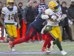 CP-Web.  Edmonton Eskimos running back Shaquille Cooper (25) is tackled by Montreal Alouettes linebacker Chris Ackie (21) as Edmonton Eskimos wide receiver Ricky Collins Jr. (13) looks on during second half CFL East Semifinal football action Sunday, November 10, 2019 in Montreal.