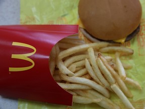 In this photo illustration, a McDonald's cheeseburger and fries are displayed on a table at a McDonald's restaurant on December 8, 2014 in Novato, California.