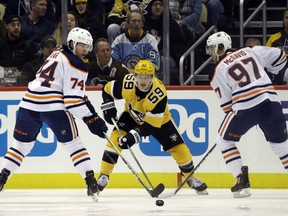 Nov 2, 2019; Pittsburgh, PA, USA;  Edmonton Oilers defenseman Ethan Bear (74) and center Connor McDavid (97) clear the puck away from Pittsburgh Penguins center Jake Guentzel (59) during the first period at PPG PAINTS Arena. Mandatory Credit: Charles LeClaire-USA TODAY Sports ORG XMIT: USATSI-405197