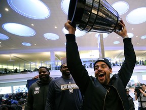 Winnipeg Blue Bombers running back Andrew Harris hoists half the Grey Cup when the team arrived at Winnipeg James Armstrong Richardson International Airport to celebrate with its fans on Monday. The top had come off the trophy during Monday's celebration.
