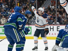 VANCOUVER, BC - DECEMBER 01:  Josh Archibald #15 of the Edmonton Oilers celebrates after scoring a goal on goalie Jacob Markstrom #25 of the Vancouver Canucks during NHL action at Rogers Arena on December 1, 2019 in Vancouver, Canada. Jordie Benn #4 and Christopher Tanev #8 look on.