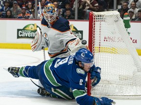 VANCOUVER, BC - DECEMBER 01:  Goalie Mikko Koskinen #19 of the Edmonton Oilers watches J.T. Miller #9 of the Vancouver Canucks fall to the ice after stopping Miller in close during NHL action at Rogers Arena on December 1, 2019 in Vancouver, Canada.