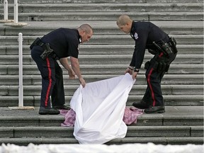 Edmonton police cover a deceased body that was found on the front steps of the Alberta Legislature on Monday, Dec. 2, 2019.
