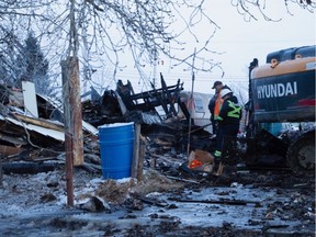 Firefighters sift through the remains of a fatal fire near Mayerthorpe, Alberta, on Friday. Five bodies were found in the house. Mayerthorpe Freelancer reporter Jordan Stricker