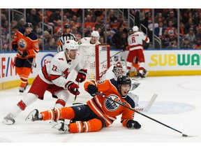 Edmonton Oilers' Ryan Nugent-Hopkins (93) is tripped by Carolina Hurricanes' Brett Pesce (22) during the third period of a NHL hockey game at Rogers Place in Edmonton, on Tuesday, Dec. 10, 2019.