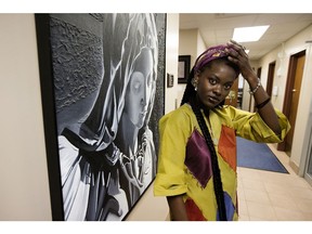 Una Momolu adjusts her head wrap as she regroups after addressing the Edmonton Catholic school board on Tuesday, Dec. 17, 2019. Una Momolu and her 11-year-old son Emmell Summerville had been demanding a full apology from the Catholic school board after school officials called the boy's durag a symbol of gang associations.
