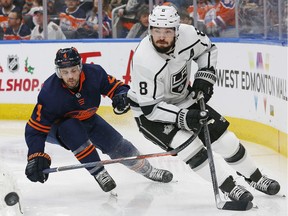 Kings defensemen Drew Doughty clears the puck in front of Edmonton Oilers defensemen Kris Russell during the second period at Rogers Place Friday, Dec. 6, 2019.
