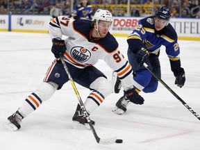 Edmonton Oilers' Connor McDavid handles the puck as St. Louis Blues' Vince Dunn defends Wednesday, Dec. 18, 2019, in St. Louis.