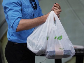 A customer leaves a Sobeys grocery store carrying plastic bags in Ottawa, Ontario, Canada, July 31, 2019. REUTERS/Chris Wattie ORG XMIT: GGG-CJW10