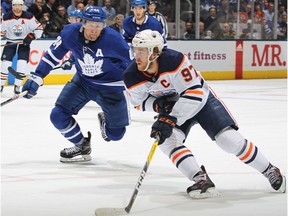 Connor McDavid (97) of the Edmonton Oilers swings around Morgan Rielly (44) of the Toronto Maple Leafs for a goalduring an NHL game at Scotiabank Arena on Jan. 6, 2020, in Toronto.