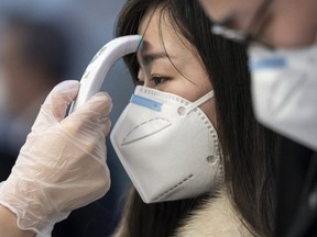 A passenger receives a temperature check before taking a flight bound for Wuhan at Spring Airlines' check-in counter at Haneda airport on January 31, 2020 in Tokyo, Japan. (Getty Images)