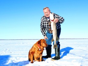 Neil and his ice-fishing dog Penny with a Pigeon Lake pike. Neil Waugh/Edmonton Sun