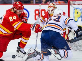 Calgary Flames defenceman Travis Hamonic (24) and Edmonton Oilers center Ryan Nugent-Hopkins (93) battle for the puck during the second period at Scotiabank Saddledome.