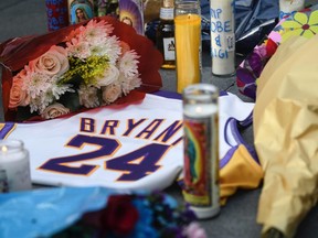 Fans mourn the loss of NBA legend Kobe Bryant outside of the Staples Center in Los Angeles on Sunday, Jan. 26, 2020.