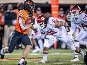 Oklahoma State Cowboys running back Chuba Hubbard (30) runs the ball against Oklahoma Sooners defensive lineman Dillon Faamatau (91) during the second half at Boone Pickens Stadium on Nov. 30, 2019.