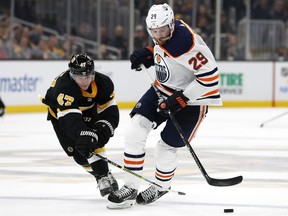 Boston Bruins defenceman Torey Krug knocks the puck away from Edmonton Oilers forwrd Leon Draisaitl during NHL action on Jan. 4, 2020, at TD Garden.