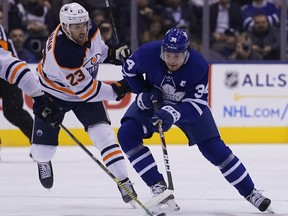 Jan 6, 2020; Toronto, Ontario, CAN; Toronto Maple Leafs forward Auston Matthews (34) carries the puck past Edmonton Oilers forward Riley Sheahan (23) during the first period at Scotiabank Arena.