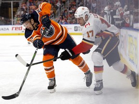 The Edmonton Oilers' Matt Benning (83) battles the Calgary Flames' Milan Lucic (17) during second period NHL action at Rogers Place, in Edmonton Wednesday Jan. 29, 2020.