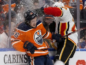 The Edmonton Oilers' Kailer Yamamoto (56) battles the Calgary Flames' Travis Hamonic (24) during first period NHL action at Rogers Place, in Edmonton Wednesday Jan. 29, 2020.
