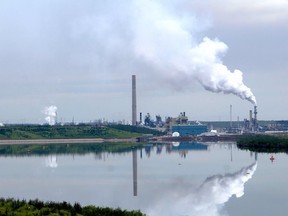 Syncrude Canada's base plant, located north of Fort McMurray, reflected in an ongoing reclamation project of a tailings pond, on Sunday, August 11, 2019.