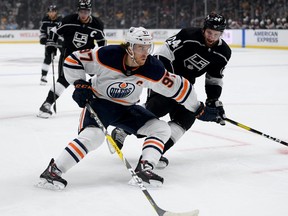 Connor McDavid #97 of the Edmonton Oilers fends off Derek Forbort #24 of the Los Angeles Kinfgs rom the puck during the first period at Staples Center on February 23, 2020 in Los Angeles, California.