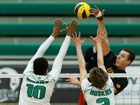 University of Alberta Golden Bears' Jackson Kennedy (8) spikes the ball past University of Saskatchewan Huskies Daven Pascal (10) and Connor Murray (2) during Canada West action at the Saville Community Sports Centre on Thursday, Feb. 20, 2020.
