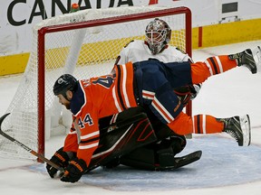 Edmonton Oilers forward Zack Kassian falls over Chicago Blackhawks goalie Robin Lehner in Edmonton on Tuesday Feb. 11, 2020.