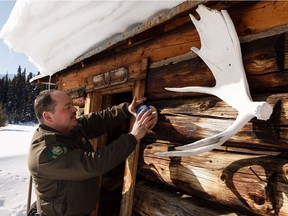 Randy Kadatz, district conservation officer with Alberta Parks, installs an Alberta Provincial Historic Resource plaque on the 1930s-era Mile 58 Summit Cabin during a trip into Willmore Wilderness Park outside of Hinton, Alberta on Wednesday, Feb. 19, 2020.