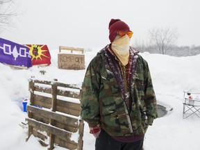 A member of the Mohawk community is shown on the Kahnawake reserve near a Canadian Pacific rail track south of Montreal, Monday, February 10, 2020 to stand in solidarity with protesters opposed to a pipeline project in northwestern B.C.