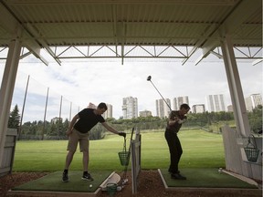 Golfers hit the driving range on a rainy afternoon at Victoria Golf Course in Edmonton.
