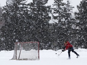 Andre Lessard plays hockey as a heavy snow falls in Edmonton's Hawrelak Park Thursday Feb. 9, 2020.