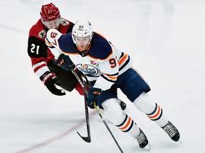 Edmonton Oilers center Connor McDavid (97) carries the puck against Arizona Coyotes center Derek Stepan (21) at Gila River Arena on Tuesday, Feb. 4, 2020.
