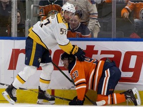 The Edmonton Oilers' Connor McDavid (97) remains on the ice following a collision with the Nashville Predators' Dante Fabbro (57) at Rogers Place on Saturday, Feb. 8, 2020.