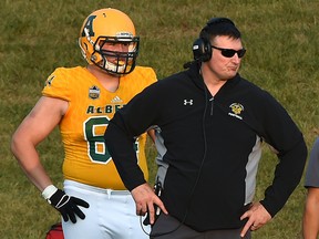 University of Alberta Gold Bears left tackle Carter O'Donnell, left, stands next to head coach Chris Morris on the sidelines against the University of Regina Rams at Foote Field on Sept. 7, 2018.
