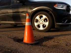 A traffic cone warns drivers of a large pothole near Concordia University at 73 Street and 111 Avenue in Edmonton, on Tuesday, April 2, 2019. Photo by Ian Kucerak/Postmedia