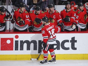 Chicago Blackhawks left wing Alex DeBrincat (12) celebrates with teammates after scoring against the Edmonton Oilers during the second period at United Center.