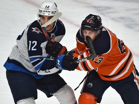 Edmonton Oilers Tyler Ennis (63) and Winnipeg Jets Dylan DeMelo (12) battle it out during NHL action at Rogers Place in Edmonton, March 11, 2020.