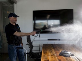 Chris Thomas, Managing Director of Ultra Shine, sprays a hydrostatically charged solution of vital oxide, a one part, stable Chlorine Dioxide disinfectant sanitizer that eliminates virus and bacteria in a boardroom on Wednesday, March 25, 2020, in Edmonton. Ultra Shine is an Edmonton-based commercial cleaning company that provides office and industrial cleaning services to businesses across Western Canada. They are trying to help others through the coronavirus outbreak, by offering to provide, free of charge, a full office sanitization for the offices of Edmonton-area non-profit, charity or community organizations that serve the vulnerable sector, to help prevent the spread of COVID-19.