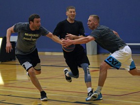 Ryan Coleman (middle) is defended by Steve Sir (left) and Jordan Baker (right) during a practice at Saville Community Sports Centre in Edmonton on Friday September 27, 2019. The teams were preparing for the FIBA 3X3 basketball tournament.