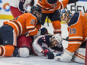 Goaltender Mikko Koskinen (19) of the Edmonton Oilers covers up a puck in front of Nick Foligno of the Columbus Blue Jackets at Rogers Place on Saturday, March 7, 2020.
