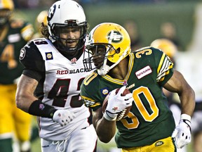 Edmonton Eskimos running back John White (30) is pursued by Ottawa Redblacks linebacker Travis Brown (43) at Commonwealth Stadium on July 11, 2014.