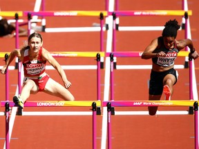 Angela Whyte of Canada, right, and Elvira Herman of Belarus compete in the Women's 100 metres hurdles heats during day eight of the 16th IAAF World Athletics Championships London 2017 at The London Stadium on August 11, 2017 in London, England.