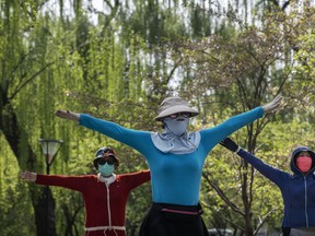 Chinese women wear protective masks as they dance in a staggered formation for exercise while enjoying the spring weather on April 5, 2020 at a park in Beijing. (Kevin Frayer/Getty Images)