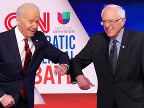 Democratic U.S. presidential candidates former vice-president Joe Biden, left, and Senator Bernie Sanders do an elbow bump in place of a handshake as they greet other before the start of the 11th Democratic candidates debate of the 2020 U.S. presidential campaign, held in CNN's Washington studios without an audience because of the global coronavirus pandemic, in Washington, U.S. March 15, 2020. (REUTERS/Kevin Lamarque/File Photo)