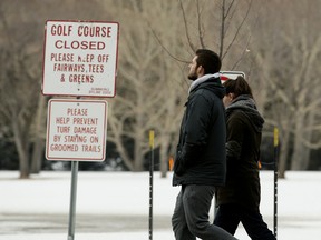Pedestrians walk through the closed Victoria Golf course, in Edmonton on Thursday, April 9, 2020.