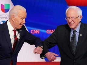 U.S. Democratic presidential hopefuls Joe Biden (left) and Bernie Sanders (right) greet each other with a safe elbow bump before the start of the 11th Democratic Party 2020 presidential debate in a CNN Washington Bureau studio in Washington, D.C., March 15, 2020.